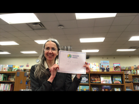 Paula Michalak holds her Sustainable Library Certification Program Certificate
